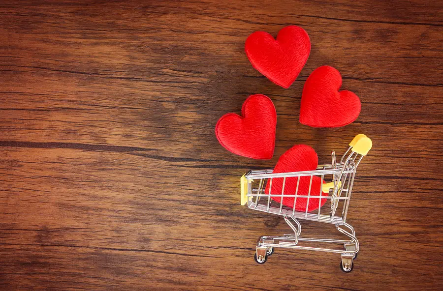 A shopping cart with red hearts inside it