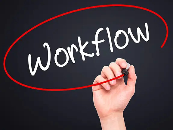 A person writing the word 'workflow'